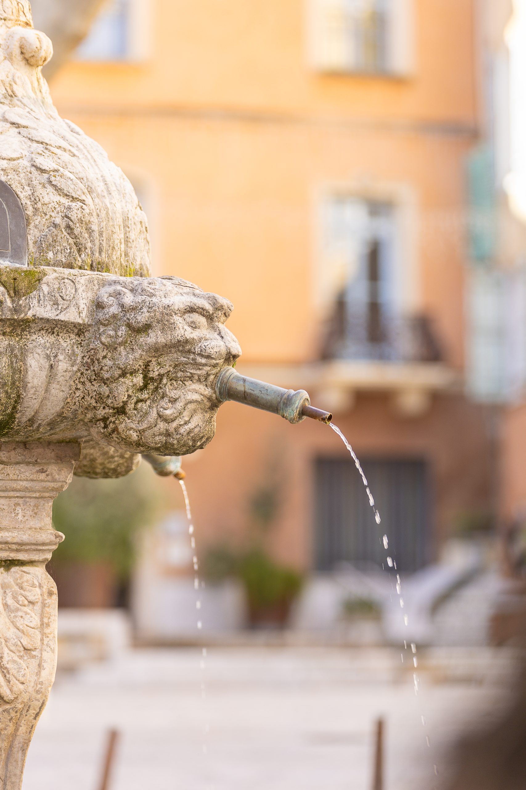 Eau coulant du mascaron d'une fontaine provençale à Cotignac en Provence Verte
