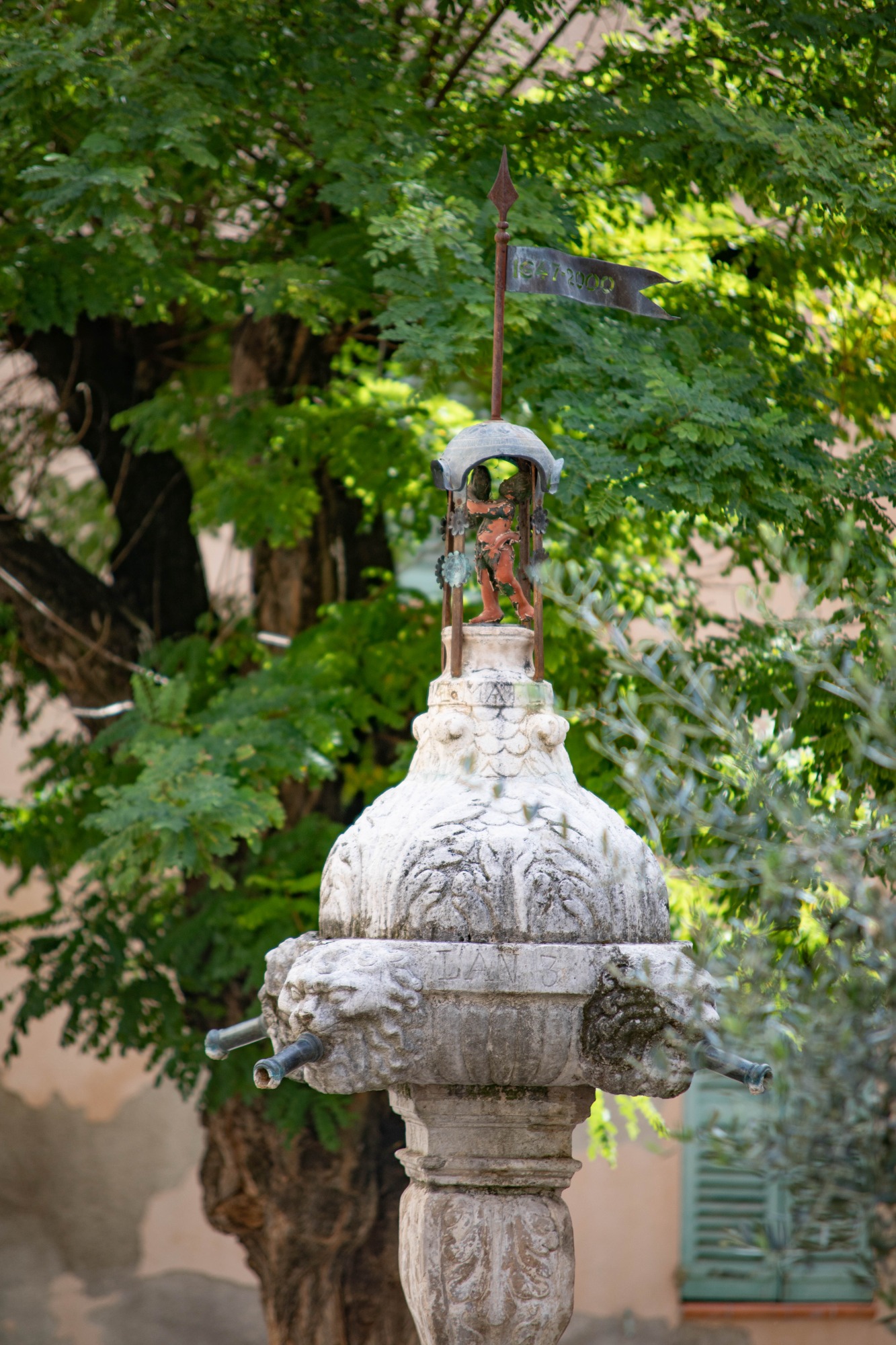 Fontaine ancienne surmontée de sa statuette au cœur du village de Cotignac